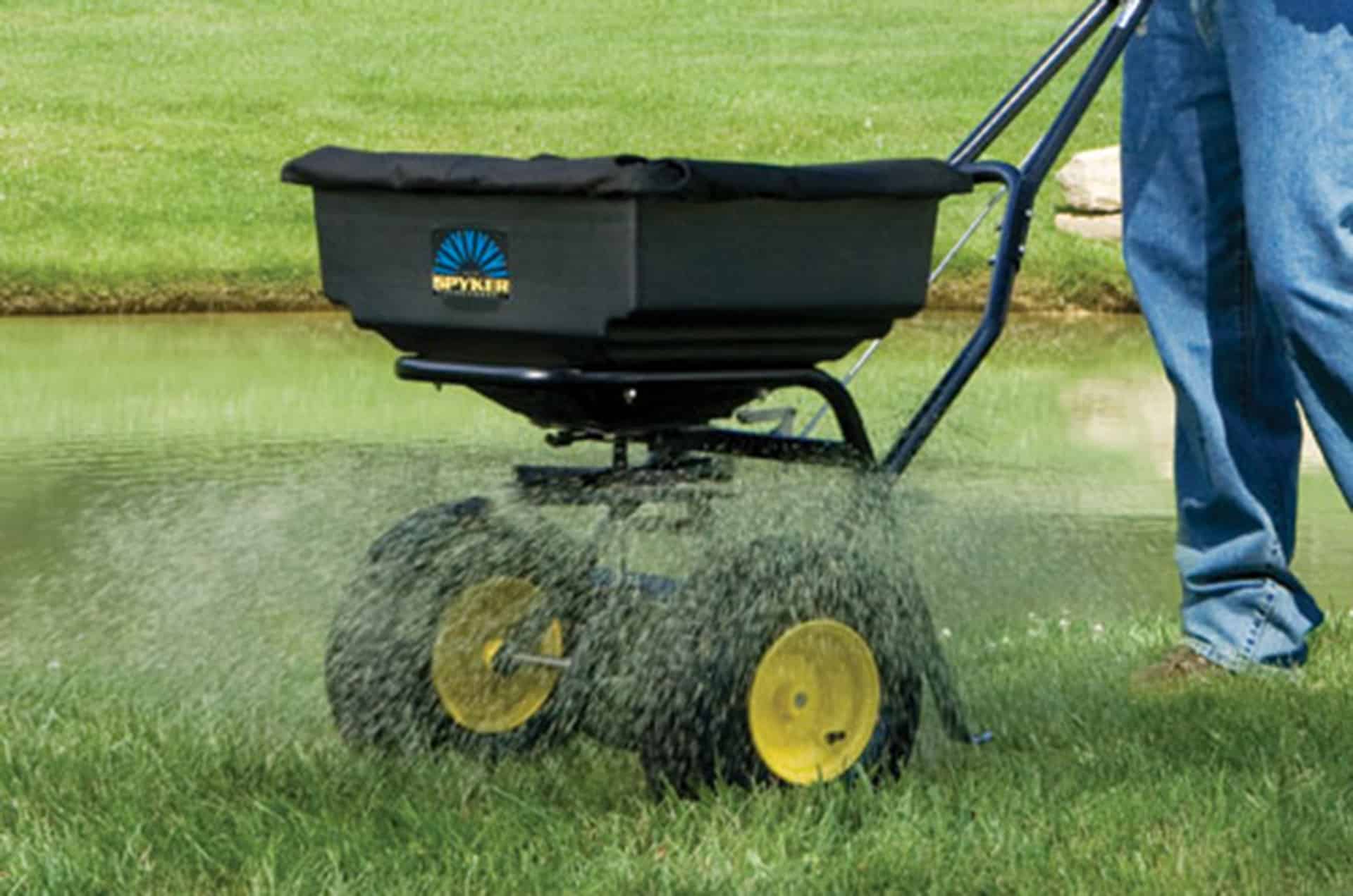 Man pushing seed spreader